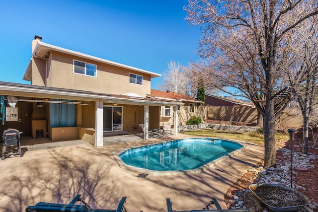 back of house featuring a fenced in pool and a patio