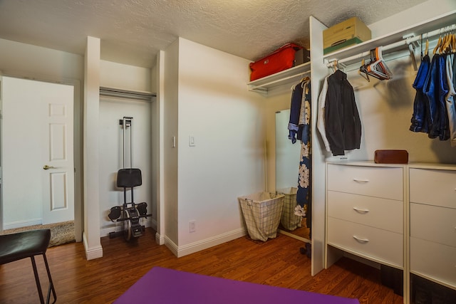 walk in closet with dark hardwood / wood-style flooring