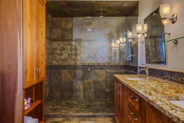 bathroom featuring vanity, tasteful backsplash, and a tile shower