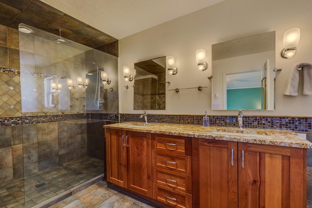 bathroom featuring tasteful backsplash, tiled shower, and vanity