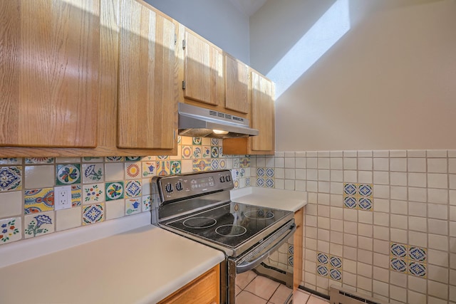 kitchen featuring tile walls, a baseboard heating unit, and range with electric stovetop