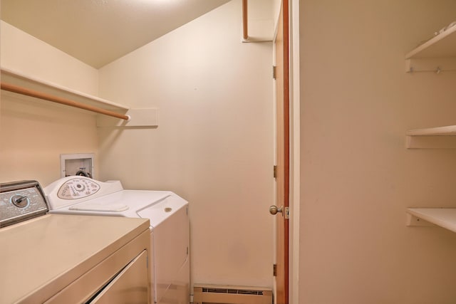 clothes washing area featuring washer and clothes dryer and a baseboard heating unit