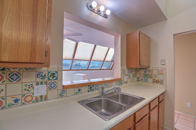 kitchen with sink, decorative backsplash, light tile patterned floors, and ceiling fan