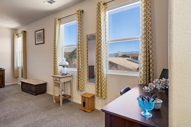 carpeted home office featuring visible vents, baseboards, and a textured ceiling