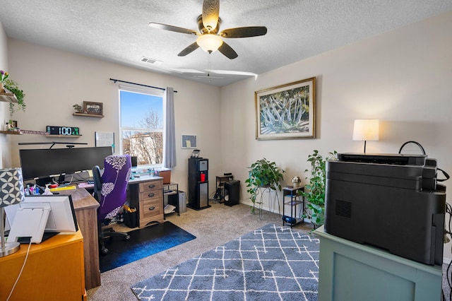 office space featuring ceiling fan, visible vents, dark carpet, and a textured ceiling