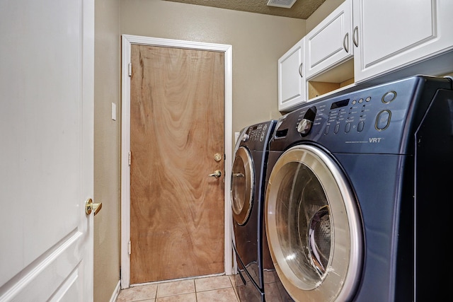 laundry area featuring light tile patterned flooring, cabinets, and separate washer and dryer