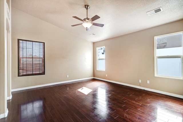 unfurnished room with dark wood-type flooring, ceiling fan, vaulted ceiling, and a textured ceiling