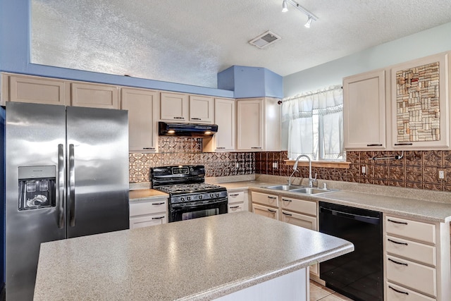 kitchen with a textured ceiling, sink, decorative backsplash, and black appliances