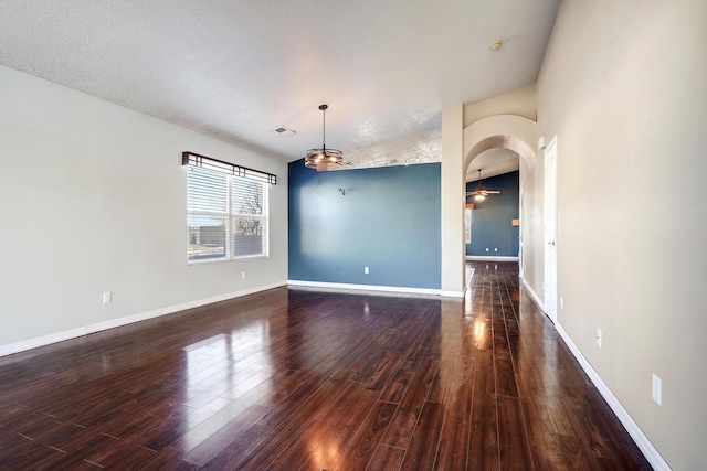 spare room featuring dark wood-type flooring and ceiling fan