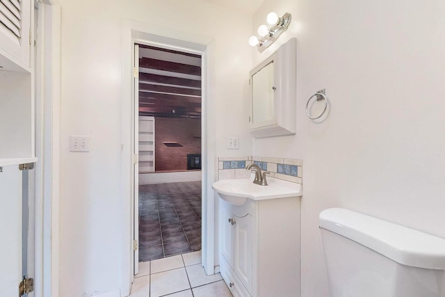 bathroom with tasteful backsplash, vanity, toilet, and tile patterned flooring