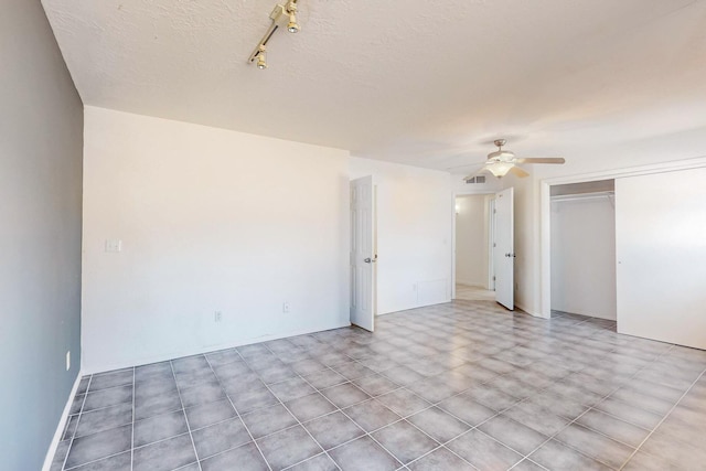 spare room with a textured ceiling and ceiling fan