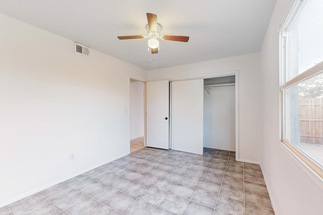 unfurnished bedroom with ceiling fan and a closet