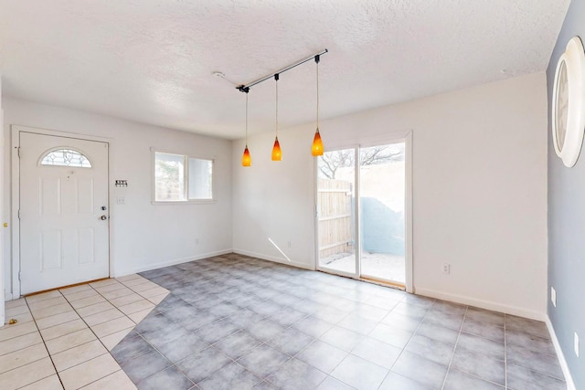 entryway featuring rail lighting and a textured ceiling