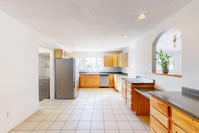 kitchen featuring stainless steel appliances, sink, a textured ceiling, and light tile patterned floors