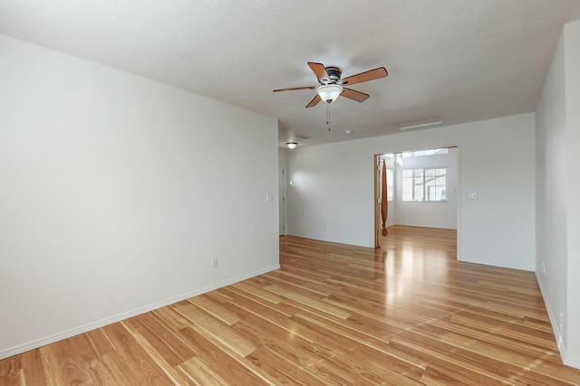 empty room featuring ceiling fan, light hardwood / wood-style floors, and a textured ceiling