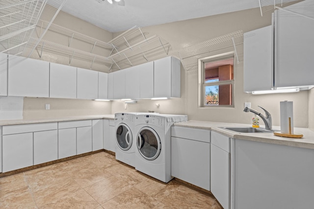 clothes washing area featuring cabinets, separate washer and dryer, and sink