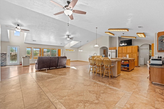 dining room with ceiling fan, high vaulted ceiling, and a textured ceiling