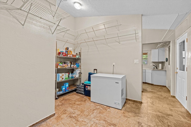 laundry area featuring sink and a textured ceiling