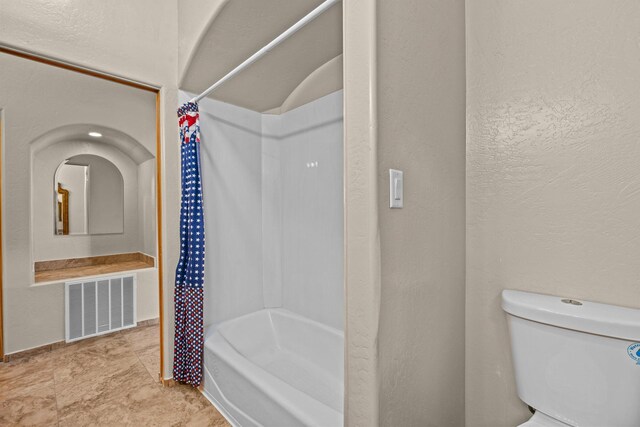 bathroom with toilet and shower / bath combo with shower curtain