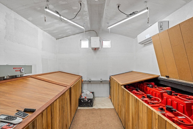 miscellaneous room with a wall mounted air conditioner and vaulted ceiling