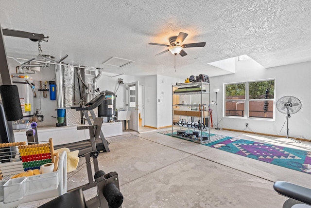 exercise room with ceiling fan, strapped water heater, sink, and a textured ceiling