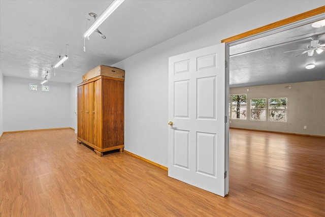 additional living space with ceiling fan, a textured ceiling, and light hardwood / wood-style floors