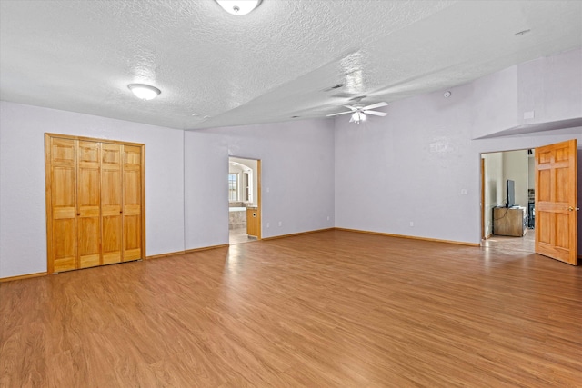 interior space with ensuite bath, light hardwood / wood-style flooring, and a textured ceiling