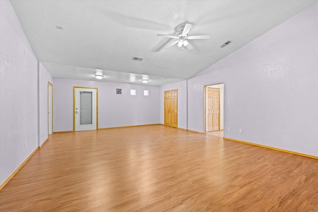 unfurnished room featuring lofted ceiling, ceiling fan, a textured ceiling, and light wood-type flooring