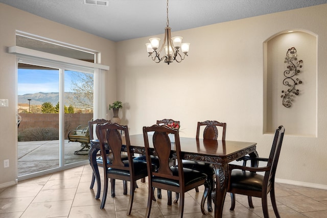 dining area featuring a mountain view, a notable chandelier, and light tile patterned floors