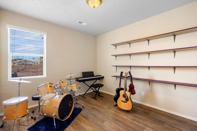 miscellaneous room featuring hardwood / wood-style flooring and a textured ceiling