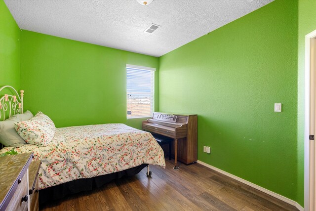 bedroom with hardwood / wood-style flooring and a textured ceiling