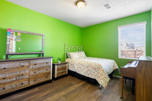 bedroom featuring dark wood-type flooring and a textured ceiling