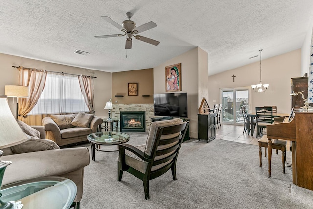 carpeted living room featuring vaulted ceiling, ceiling fan with notable chandelier, a textured ceiling, and a fireplace