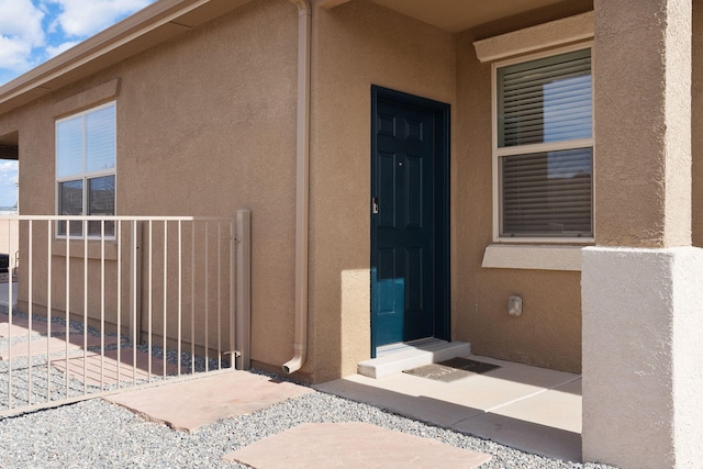 view of exterior entry featuring stucco siding