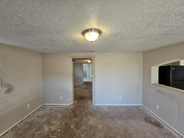 unfurnished room featuring a textured ceiling