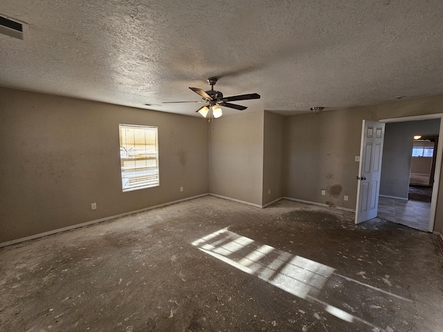 unfurnished room featuring plenty of natural light, a textured ceiling, and ceiling fan