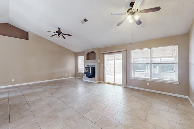 unfurnished living room with vaulted ceiling, a fireplace, light tile patterned floors, ceiling fan, and a textured ceiling