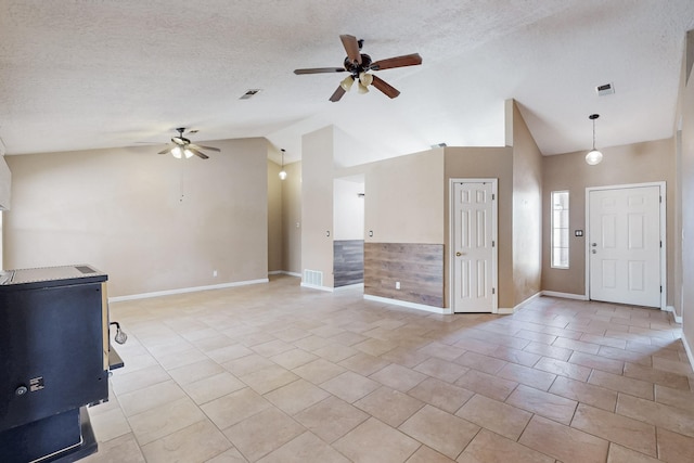 unfurnished living room featuring lofted ceiling, ceiling fan, light tile patterned floors, and a textured ceiling