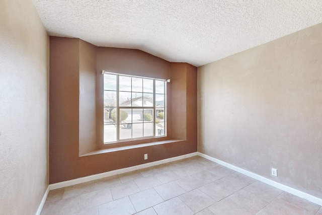 unfurnished room featuring lofted ceiling and a textured ceiling