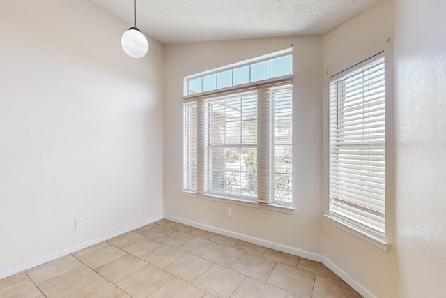 tiled spare room featuring lofted ceiling and a textured ceiling