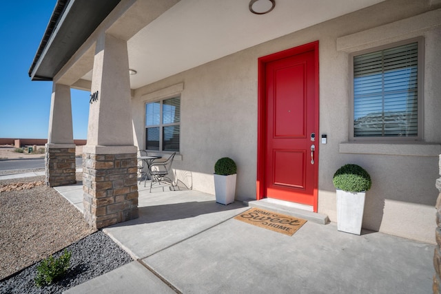 property entrance with a patio area, outdoor dining area, and stucco siding