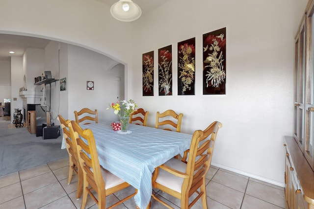 dining area featuring light tile patterned flooring and a fireplace