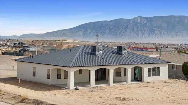 1145 15th St SE, Rio Rancho, NM 87124 - back of house featuring a mountain view, central AC unit, and a patio area