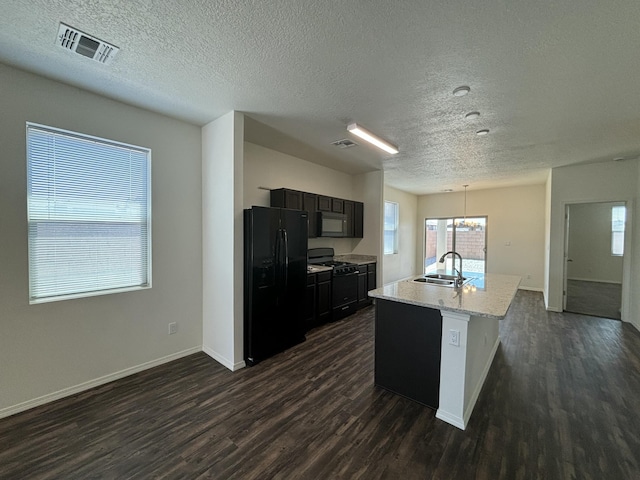 6232 Winter Hawk Dr NE, Rio Rancho, NM 87144 - kitchen with visible vents, an island with sink, dark wood-style flooring, a sink, and black appliances