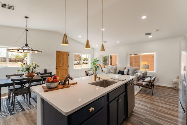 kitchen with pendant lighting, sink, wood-type flooring, an island with sink, and stainless steel dishwasher