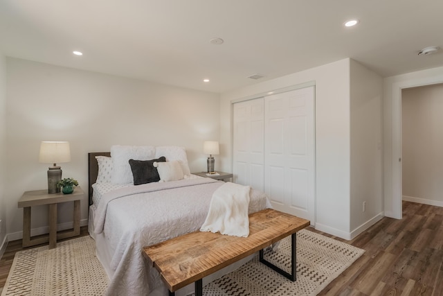 bedroom with dark hardwood / wood-style floors and a closet