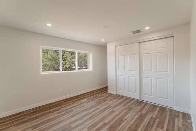 unfurnished bedroom with a closet and light hardwood / wood-style flooring