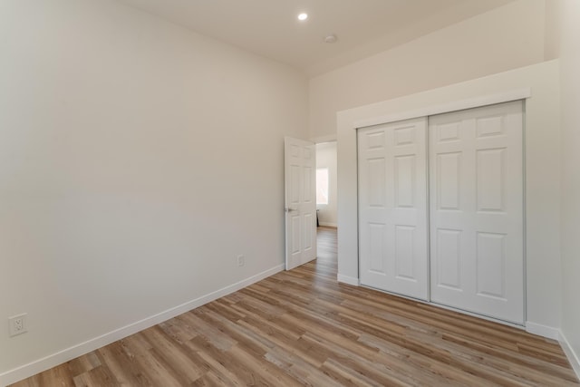 unfurnished bedroom with light hardwood / wood-style floors and a closet