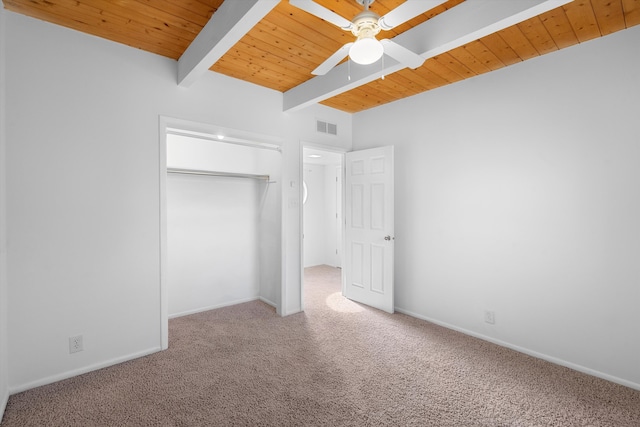 unfurnished bedroom featuring ceiling fan, beam ceiling, carpet, wooden ceiling, and a closet