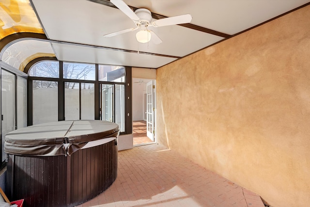 sunroom featuring a jacuzzi and ceiling fan